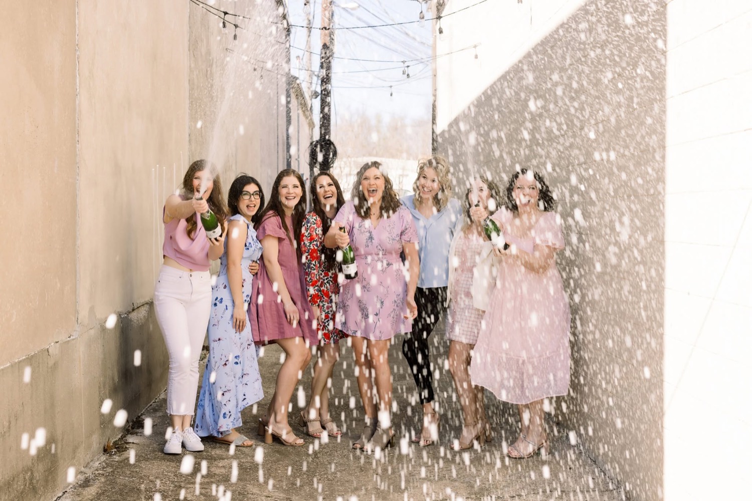 The CM Promotions planning team popping champagne together to celebrate